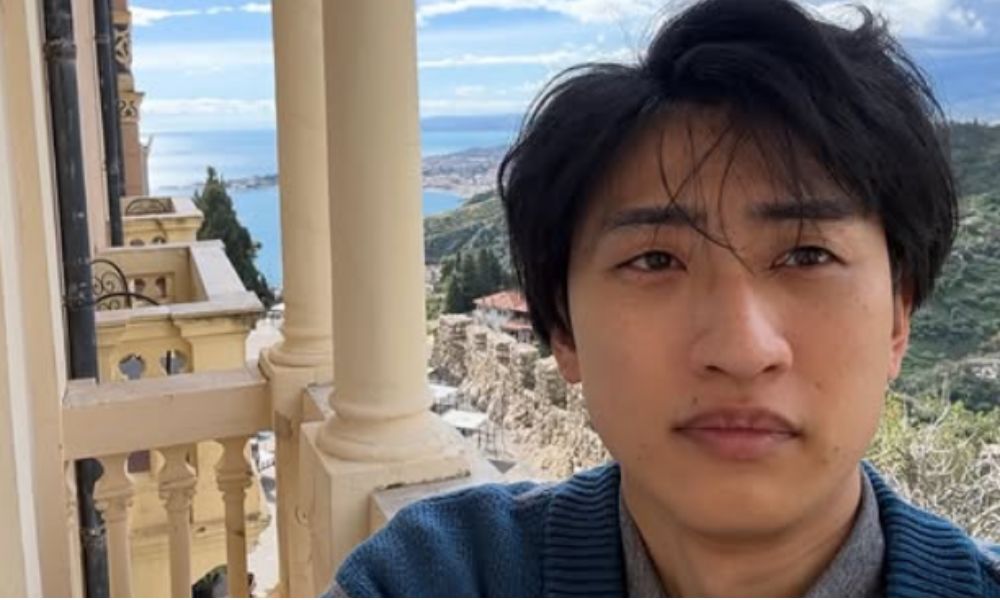 お笑い芸人・土岡哲朗（春とヒコーキ）の自撮り写真。海と街並みを望むバルコニーでのショット