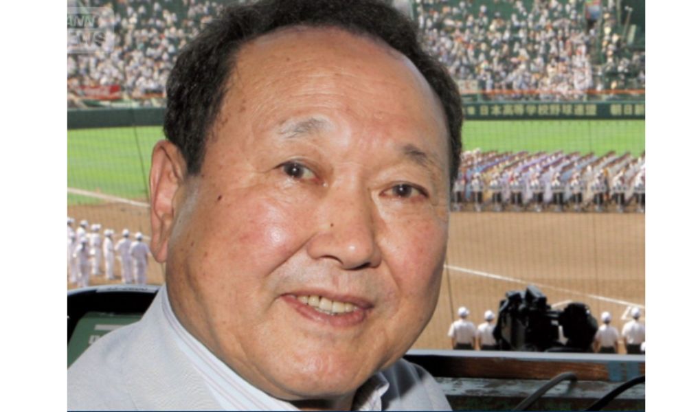 野球場を背景に笑顔を見せる板東英二
