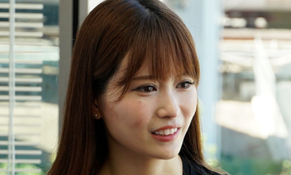 インタビュー中に優しい笑顔を見せる岡本詩菜さんのポートレート