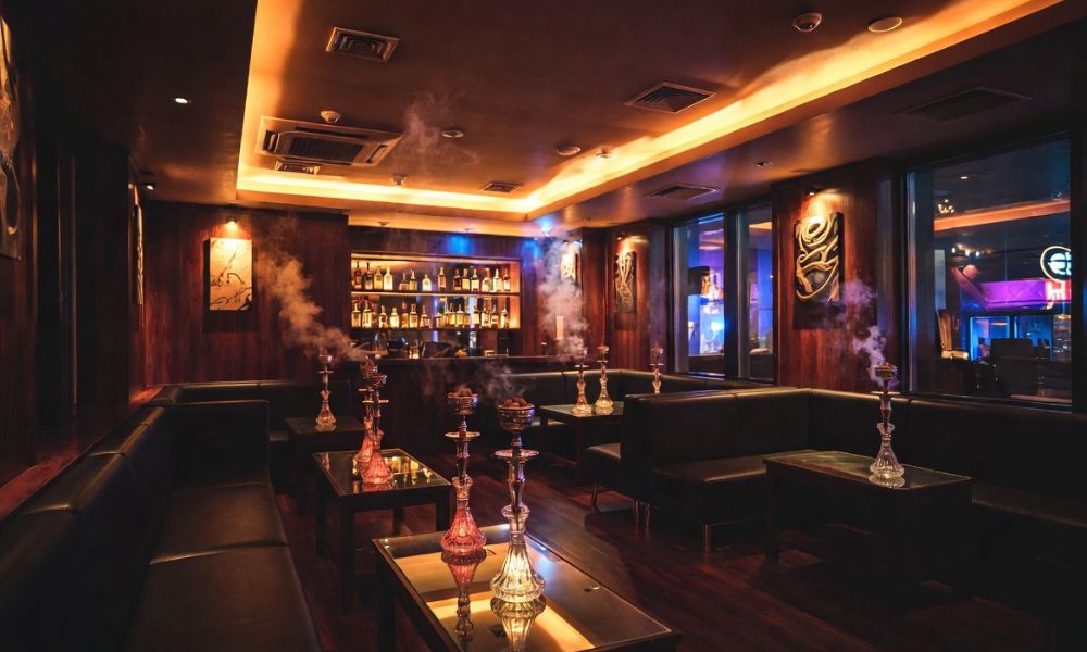 六本木の高級シーシャバー店内のリアルな雰囲気 暗い照明と煙が漂う空席の個室風ラウンジ 人物なし